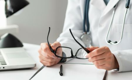 Lekarz trzymający okulary w dłoniach