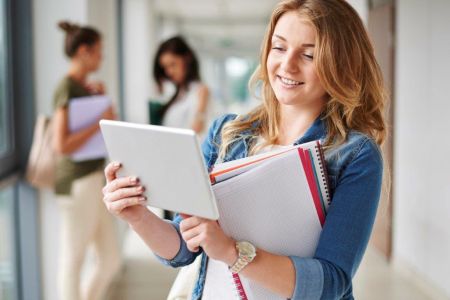 studentka z tabletem i książkami w ręce
