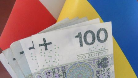 Banknoty na tle flag Polski i Ukrainy